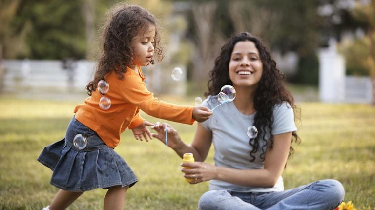 Mother and daughter playing with bubbles