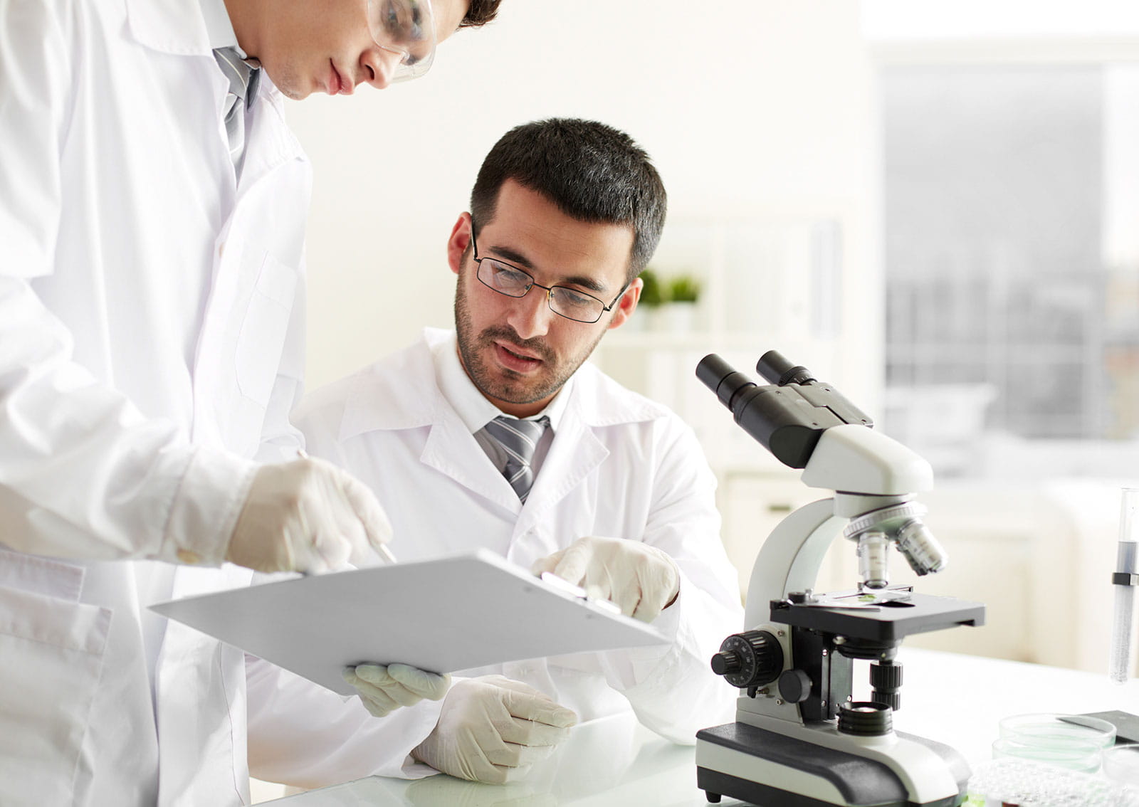 Two male scientist looking at a clipboard